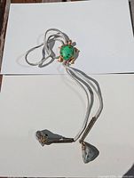 Full view of bolo tie showing turtle slide, cord and blue stone tips