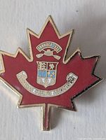 Front view of maple leaf enamel lapel pin showing crest and text