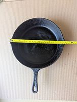 Top view of cast iron skillet with tape showing 11-inch diameter