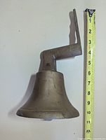 Side view showing full bell and measuring tape to indicate height ~9 in