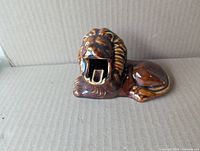 Front view of brown glazed ceramic lion ashtray