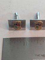 Both cufflinks beside ruler showing size ~16 mm
