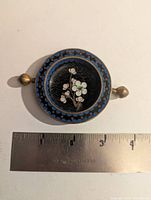 Top view showing cherry blossom motif, blue rim, brass rests, ruler for scale