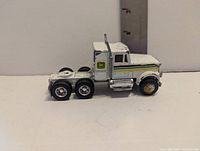 Left side view of white Ertl John Deere semi cab showing decals and wheels