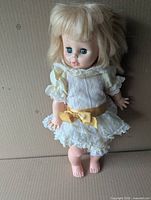 Front view of 17" Eugene blonde doll in original striped dress with yellow ribbon