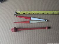 Hook remover and two bobbers beside tape for scale