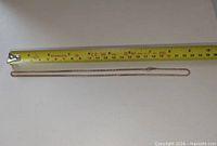 Full view of 18-inch gold-tone Avon chain next to measuring tape