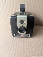 Front view showing lens, viewfinder, nameplate