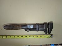 Full view of 12" Coes monkey wrench beside tape measure