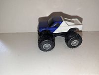 Side view of blue/white monster truck showing body colors and wheel condition