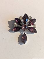 Front view showing purple and pink navette stones, clear round rhinestones, floral design with dangling navette drop
