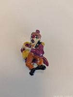 Front view of resin clown brooch showing colours and motif
