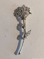 Front view of silver tone floral brooch with aurora borealis rhinestones