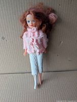 Front view of Sindy doll wearing pink knit cardigan, white knit pants, one boot