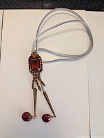 Entire bolo tie showing cord, slide and dangles