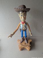 Full view of Woody figure on base, hat on