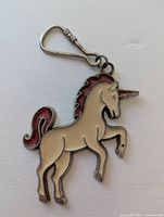 Front view of unicorn-shaped metal key chain showing enamel colors and hook