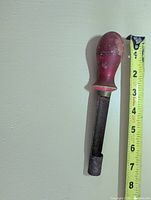 Full view of apple corer beside tape measure showing ~9 inch length