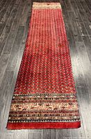 Full view of red Persian runner showing pattern and dimensions perspective