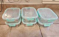 Six stacked glass containers with lids shown from front