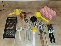 All kitchen utensils laid out on tile floor for overview