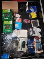 Drawer containing Spax screw boxes, Sylvania bulb pack, braces, staples, assorted screws and washers