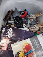 Interior of bin showing Marvel Studios instruction pages, black chassis, tan animal legs and assorted bricks