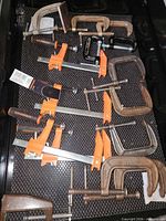 Drawer view showing mix of C-clamps and orange-jaw bar clamps