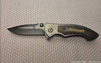 Knife open showing full blade, handle, pocket clip and Browning logo