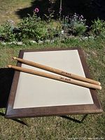 Top view of pair of oversized Pro-Mark drumsticks on table