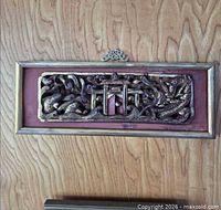 front view of gilded wood plaque against door