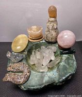 Full view showing bowl filled with assorted crystals and carvings