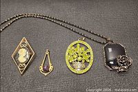 Group view of four jewelry pieces laid flat