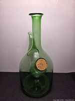 Front view of green glass decanter highlighting neck, spout, and corked ice chamber