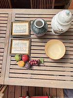 lot overview showing framed prints, two vases, pedestal bowl and faux fruit