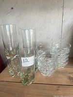 Group of tall highball glasses and stacked dessert bowls