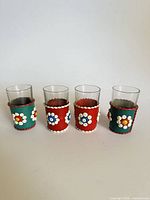 Front view of four leather-sleeved shot glasses