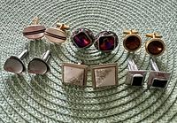 All six pairs of cufflinks arranged on woven mat