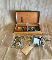 Overview of wooden box, keys, padlock and plastic case