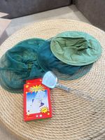 Two folded bug nets, boxed bingo game, stainless spatula on mat