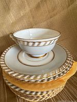 teacup atop saucer on stack of saucers showing pattern and trim