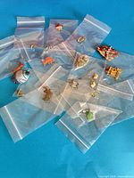 All jewellery pieces in individual bags spread on blue background