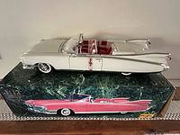 Side view of white Eldorado model atop original Maisto box