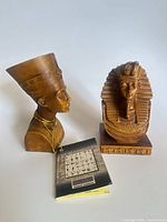 Both Egyptian resin busts with tag visible