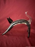 Side view of entire glass cat figurine showing arched body and clear tail