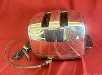 Front view of Sunbeam chrome toaster showing reflective surface, two slots, attached cord