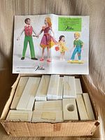 Box with stacked plastic mold halves and open instruction booklet showing finished figure examples