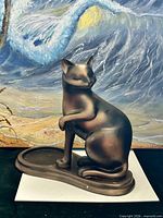 Front view of bronze-tone resin cat figurine with attached dish