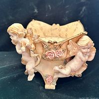 Oblique front view showing cherub figures and floral appliqués