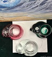 Top view of three glass votive holders showing colors and candle wells
